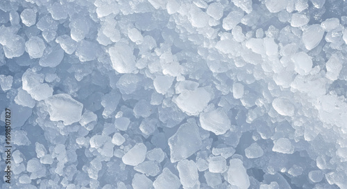 Close-up top view of various pieces of crushed ice, forming a cool, sparkling blue and white textured background, perfect for winter themes.