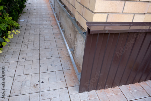 Repair of the foundation and walls of the house with the installation of metal sheets on the frame for finishing the basement.