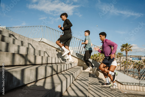 A group of five athletes running up the stairs