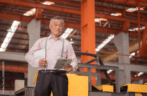 Wallpaper Mural Senior experienced technician checking large machine on a production line Torontodigital.ca
