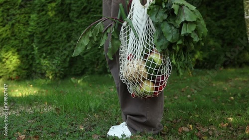Woman with String Bag Full of Spring Vegetables