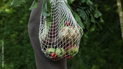 Woman with String Bag Full of Spring Vegetables