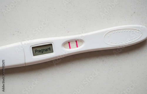 A positive pregnancy test showing two lines and a 'Pregnant' result, a sign of new life and family