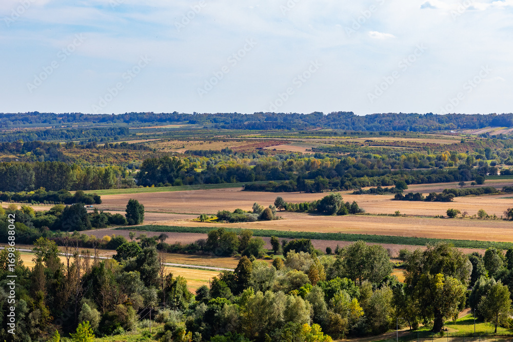 Obraz premium Rolling valley landscape with fields, forests and distant hills
