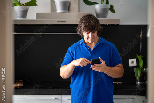 Man Multitasking with Phone and Pan in Stylish Kitchen