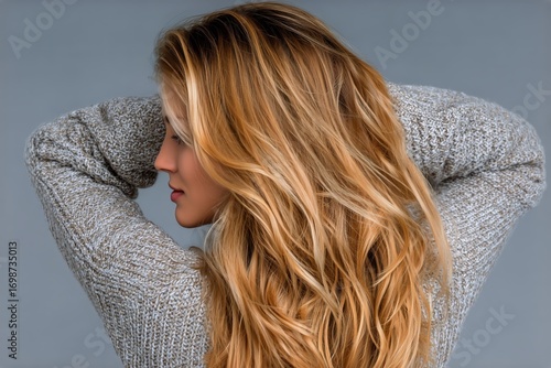 Long Wavy Blonde Hair Styled Elegantly With a Cozy Sweater in a Neutral Setting.