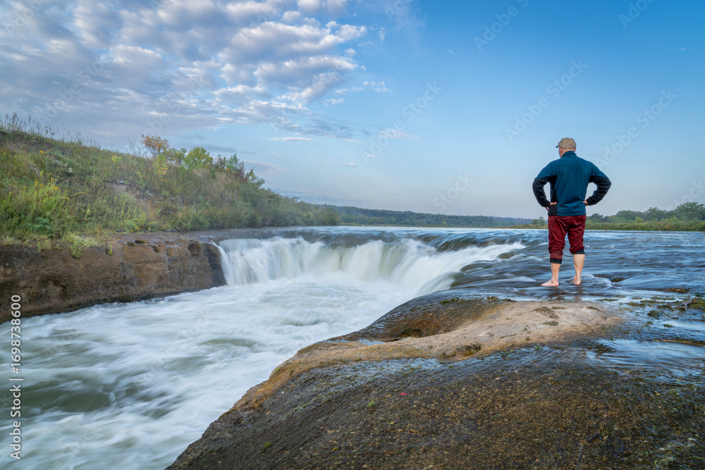 Obraz premium lonely man contemplating the Norden Chute on Niobrara River in Nebraska, late summer sunrise scenery
