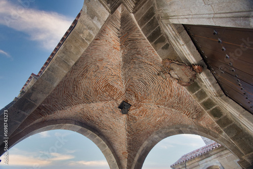 Photos Architectural detail of an old vaulted ceiling - A low-angle shot of a ribbed vault ceiling made of brick and stone, part of an old church or historic building