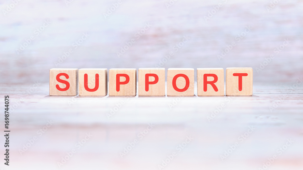 Fototapeta premium The concept word SUPPORT is made of wooden cubes on a light background. Business and SUPPORT concept. Copy space
