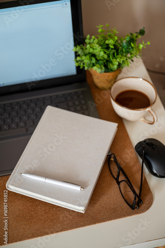 Notebook planner on a desk with laptop and coffee cup 