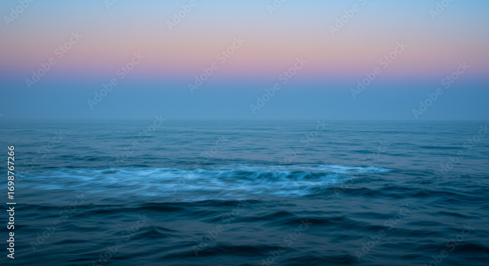 Obraz premium Serene ocean waves at dawn with soft pastel sky creating a peaceful, calming, and tranquil atmosphere for relaxation and meditation