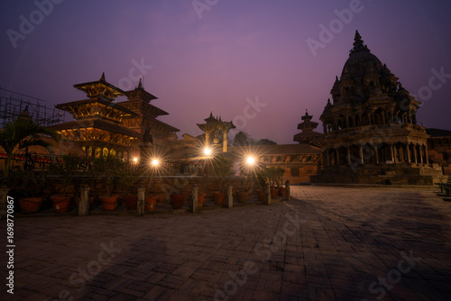 Magic view of Patan Durbar Square in Kathmandu, Nepal. Traditional Newari architecture with illuminated temples and purple sky. Historical UNESCO World heritage with cultural and architectural beauty.