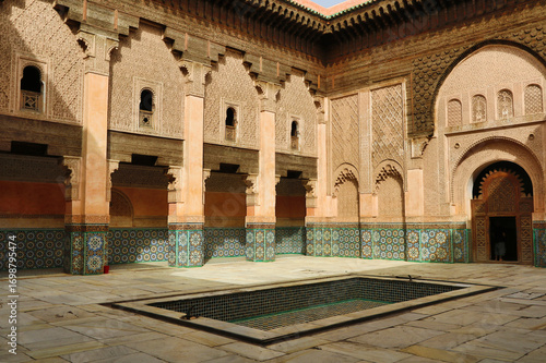 Foto Moroccan Madrasa courtyard with pond - A wide shot of the beautiful courtyard of the Ben Youssef Madrasa, showing its central pond and detailed architecture