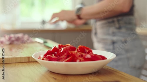 Mid adult woman preparing for cooking in modern kitchen at home, wearing casual cloth. Female chef following food recipe, hands cleaning and slicing vegetables.