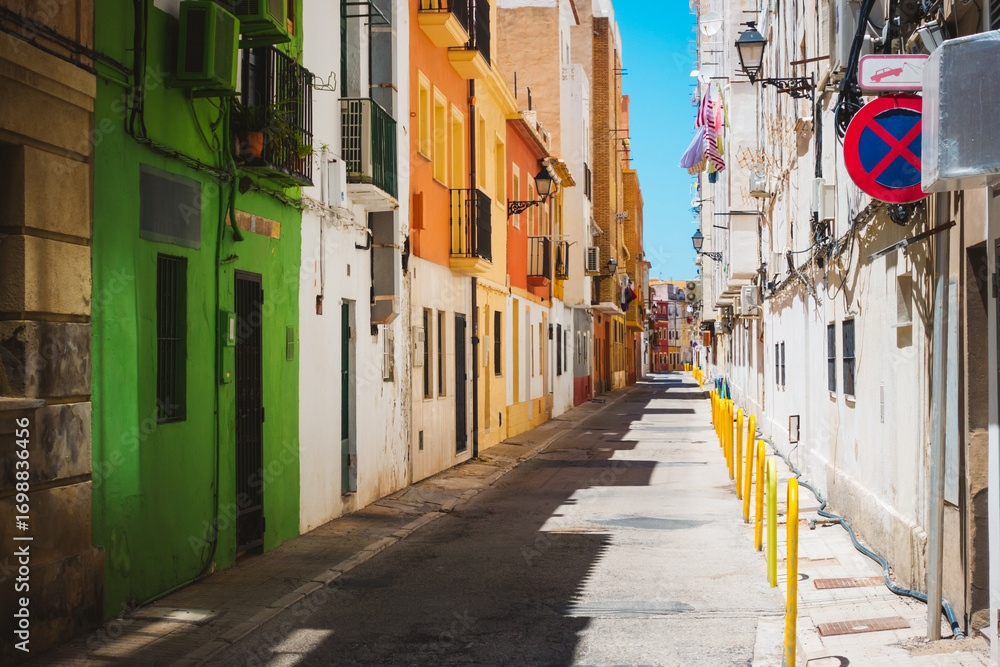 Obraz premium Historic buildings on a typical street in the old part of the coastal Denia town. Location place province of Alicante, Costa Blanca, Valencian Community, Spain, Europe.