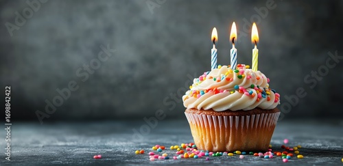 Celebratory Birthday Cupcake With Three Burning Candles Sitting on a Countertop