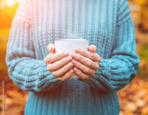 Hands Holding Warm Mug in Cozy Autumn Sweater