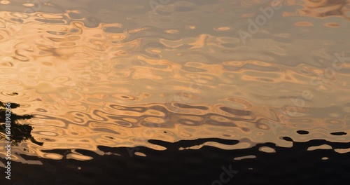 River shore golden light reflections shadows on water ripples hypnotic nature