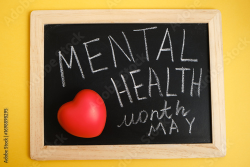 red heart and chalk writing on black board mental health month may, emotional health concept