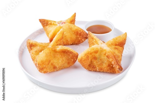 Crab rangoon with sauce in a plate on a white isolated background