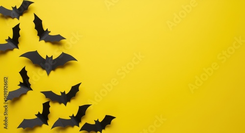 Halloween decorations – paper bats on a yellow background on the side, copy space in the center. Happy Halloween banner 2025 -2026 with bats