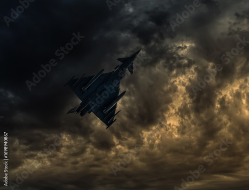 Dramatische Untersicht eines Kampfjets in den Wolken