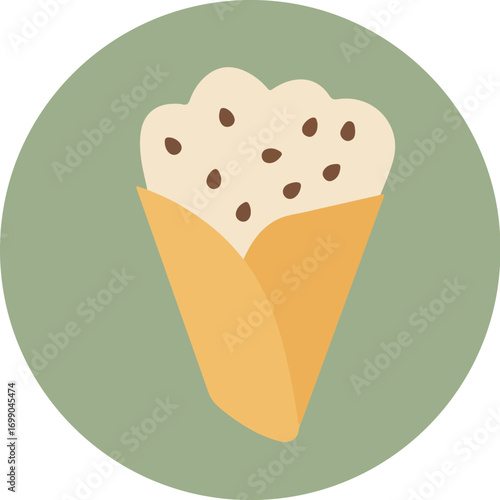 Close-up of a waffle cone with white ice cream and dark chocolate chips on a green background