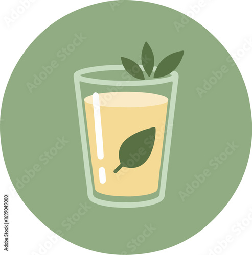 Glass of light orange beverage with green leaves and straw on soft green background