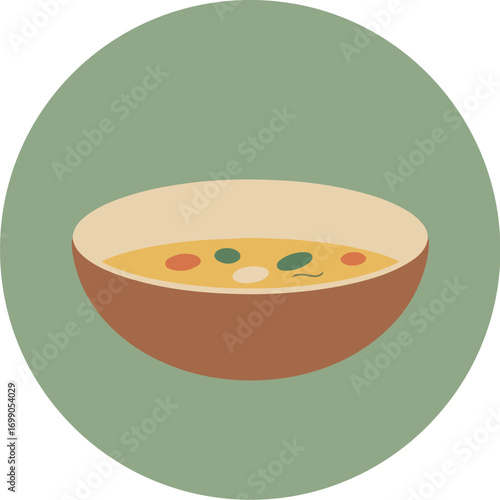 Rustic brown bowl with creamy yellow soup and colorful garnishes on green background