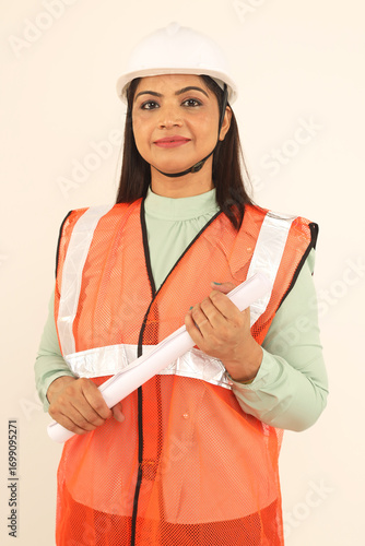 Portrait of happy Young woman architect confident woman builder architect standing and looking Infront of the camera. wearing hardhat. Studio isolated portrait.