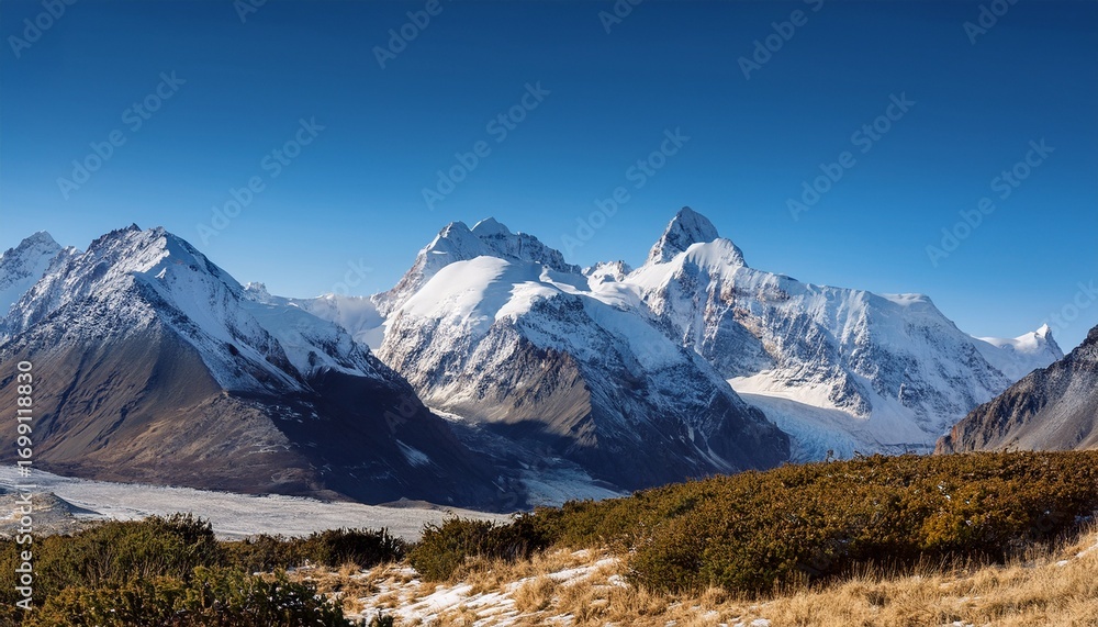 Fototapeta premium majestic snow capped mountains under a clear blue sky in a tranquil outdoor landscape