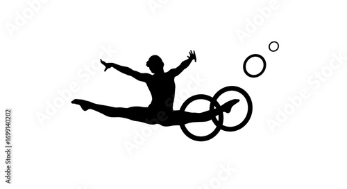 Silhouette of a gymnast performing a split leap with rings