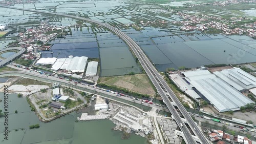 Aerial perspective of flooded urban landscape with elevated expressway system reflecting climate