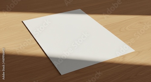 A blank white paper lies on a wooden surface with a shadow