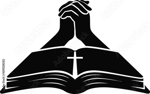 Silhouette of praying hands above an open bible with a cross