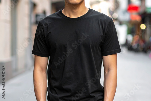 Generative AI image featuring a man wearing a plain black t-shirt, perfect for fashion mockups and urban lifestyle themes.