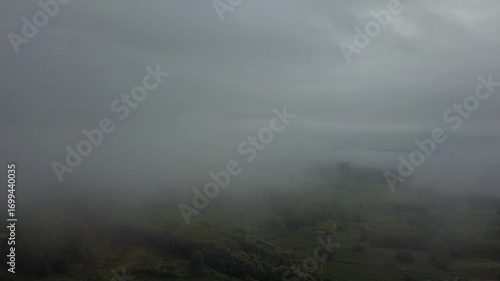 Thick valley fog. A dark pine forest is in the foreground, creating a dramatic and atmospheric alpine landscape.
