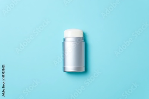 Silver aerosol can with white brush cap on a light blue background