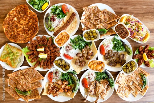 Delicious meat kebab with fresh vegetable salad served with variety of Turkish dishes and appetizers. Top view of assorted Turkish food and meze, tasty and healthy Mediterranean cuisine. Top view.