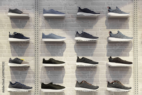 Принти на полотні Shop display of unbranded modern new stylish sneakers running shoes for men on brick wall background texture