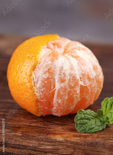 Fresh Peeled Mandarin Orange Segments with Mint on Wood Surface