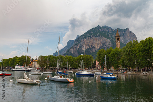 Lecco, Italy - May 21, 2025: Boats on the lake and town waterfront