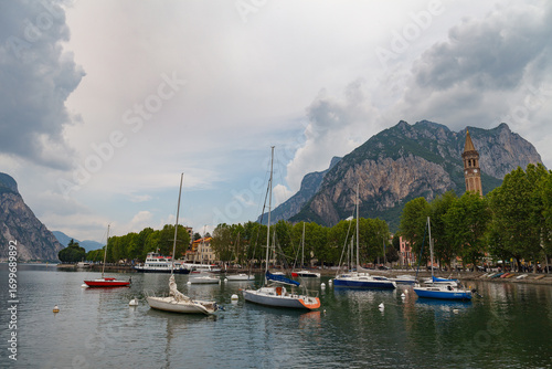 Lecco, Italy - May 21, 2025: Boats on the lake and town waterfront
