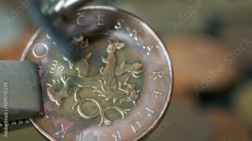 Man cleaning a 50 Czech crown with rotary tool. 4k footage UHD 3840x2160