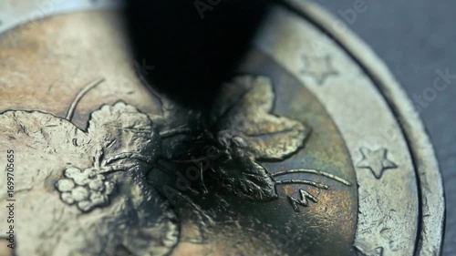 Man cleaning a EURO coin with rotary tool. 4k footage UHD 3840x2160