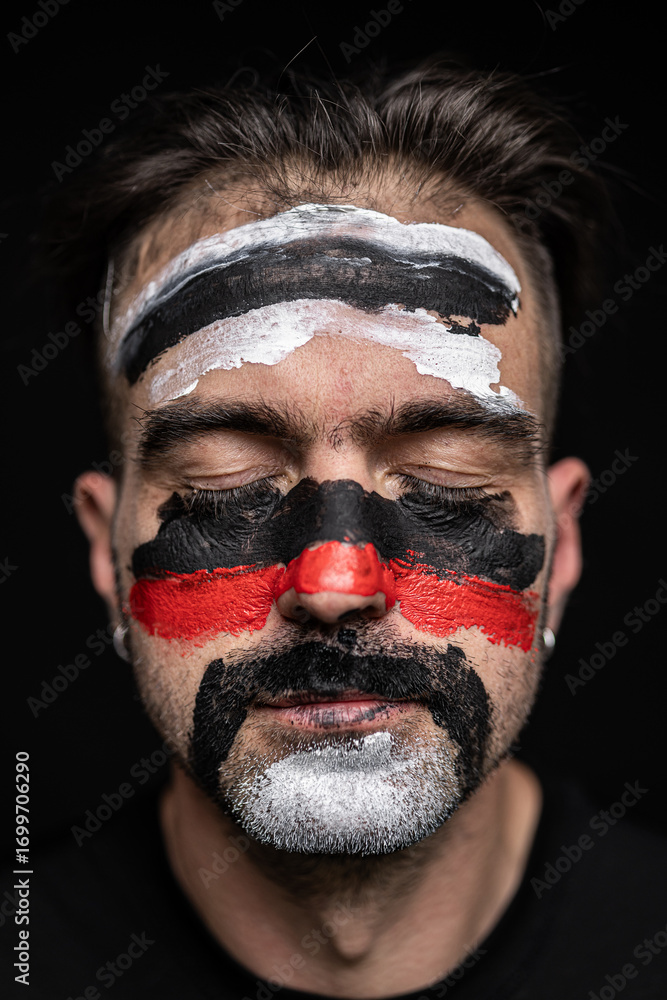 Fototapeta premium Man with Tribal Face Paint in Black Red White
