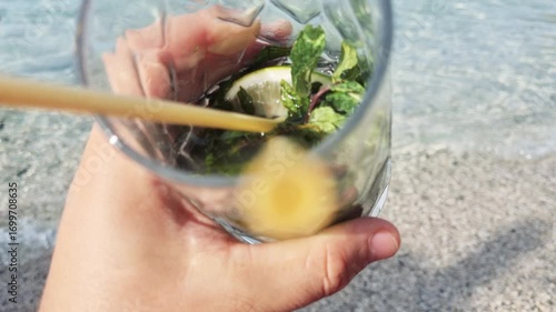 Man drinking cold beverage with the straw ia a beach. 4k video footage in slow motion