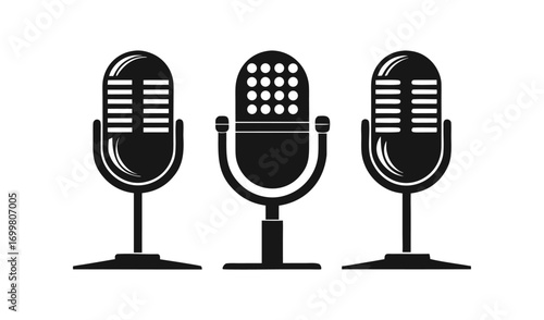 Three vintage microphones on stands in a row on a white background