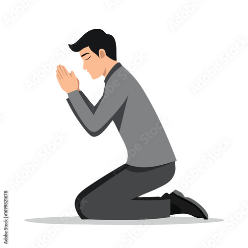 A man in a suit kneels in prayer, hands clasped together, head bowed in devotion.