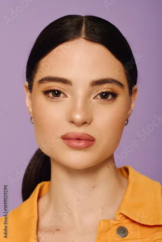 Obraz A young woman showcases her beauty and style with a bold outfit and captivating gaze.